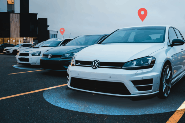 A row of high-value cars in a dealership lot being protected by advanced GPS tracking technology, indicated by location pin icons above the vehicles.